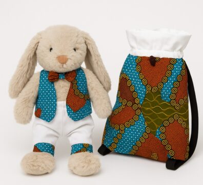 Un lapin en peluche habillé d’une tenue cousue main, accompagné d’un sac assorti fabriqué dans le même tissu.